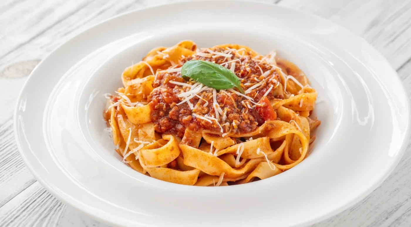 A plate of tagliatelle al ragù topped with grated Parmigiano — the dish that makes the case for Bologna as Italy's food capital
