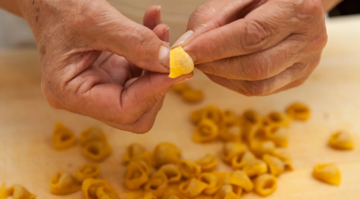 Hands shaping fresh tortellini by hand in Bologna